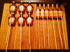 several brown bottles are lined up on a bamboo mat with toothpicks in front of them