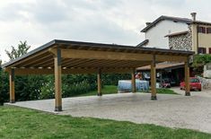 a covered parking lot in front of a large house