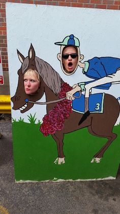 a man riding on the back of a brown horse next to a painting of a jockey