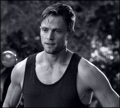 a black and white photo of a man in tank top