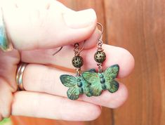 "I hand patina these beautiful metal butterfly to create a green verdigris coloring. The green verdigris patina has been sealed with lacquer to insure a very durable finish. A simple 5mm antique brass filigree ball sit a top the sweet butterflies. They measure 1 ½\" from the top of the antique brass earrwires. The butterflies measure ¾\" in width. See more of my jewelry designs here: https://www.etsy.com/shop/JensBeadBox All my jewelry comes gift boxed with a bow ready for gift giving whether it Unique Green Butterfly Earrings, Green Adjustable Jewelry With Butterfly Charm, Green Bohemian Butterfly Jewelry, Bohemian Green Butterfly Jewelry, Green Butterfly Nature-inspired Jewelry, Nature-inspired Green Butterfly Jewelry, Pierced Green Copper Earrings, Green Copper Pierced Earrings, Green Copper Earrings For Gift