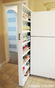 a white refrigerator freezer sitting inside of a kitchen next to a pantry filled with food