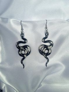 Black and Silver Leaf statement snake earrings. Ear Hooks are stainless steel.  Handmade from resin and silver leaf.  Historically, serpents and snakes represent fertility or a creative life force. As snakes shed their skin through sloughing, they are symbols of rebirth, transformation, immortality, and healing. Snake Shedding, Snake Earrings, Ear Hook, Creative Life, Black And Silver, Silver Leaf, Jewelry Earrings Dangle, Cross Necklace, Etsy Earrings