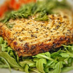 a close up of a plate of food with meat and greens on it's side