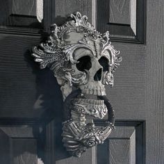 a metal door handle with a skull on it's face and an ornate design