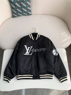 Embrace sporty sophistication with the Louis Vuitton-inspired Embroidered Nylon Baseball Blouson. This statement jacket reimagines classic varsity styling with a luxurious touch. The sleek black nylon is adorned with eye-catching embroidered patches, showcasing "LV Lovers" lettering and playful motifs. The contrasting ribbed collar, cuffs, and hem offer a snug fit and a touch of sporty flair. This versatile blouson is perfect for layering and adds a touch of high-fashion to any casual ensemble. Blouson Jacket, Statement Jacket, Loafer Sneakers, Bottega Veneta Shoulder Bag, Black Nylon, Black Nylons, Brunei, Embroidered Patches, Snug Fit