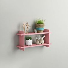 two pink shelves with plants on them against a gray wall, one has a potted plant and the other is an animal figurine