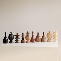 a group of chess pieces sitting on top of a white table next to each other