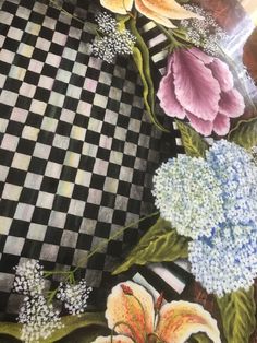 a painting of flowers on a black and white checkered table cloth