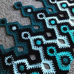 crocheted black and teal afghans on the floor