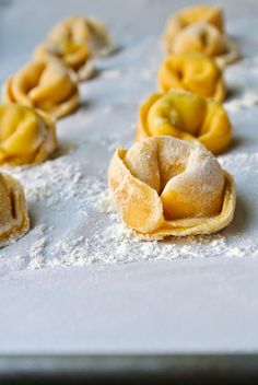 small pastries are lined up on a baking sheet