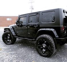 a black jeep is parked in a parking lot