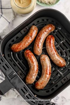 sausages are being cooked in an air fryer