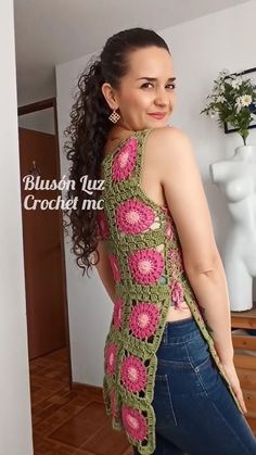 a woman in jeans and a crochet top is smiling at the camera with her hands on her hips