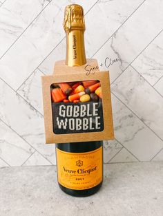 a bottle of gobble wobble wine in a cardboard box with a corkscrew on top