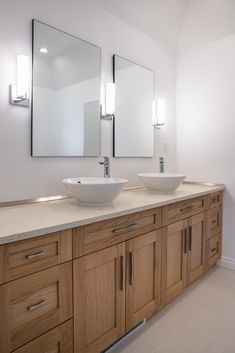 a bathroom with two sinks and mirrors in the middle of it's countertop