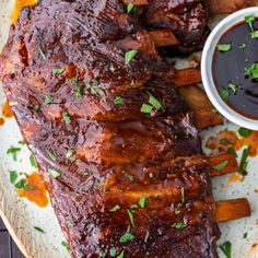 ribs and french fries on a plate with ketchup, sauce and parsley