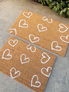 two door mats with hearts drawn on them