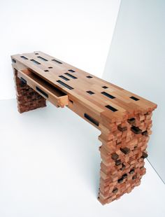 a wooden bench made out of bricks sitting on top of a white floor next to a wall