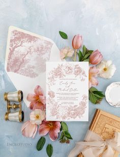 the wedding stationery is surrounded by flowers and other items