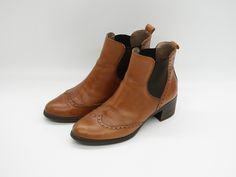 "Embrace timeless elegance with our Cognac Brown Leather Chelsea Wingtip Boots, meticulously crafted in Spain for the discerning woman. These boots feature a classic wingtip design with exquisite broguing details, adding a touch of sophistication to any ensemble. The low block heels offer both style and comfort, perfect for all-day wear. Made from premium leather with elastic side panels and pull straps, these boots ensure a snug yet flexible fit. Whether paired with jeans for a casual outing or Wingtip Boots, Womens Booties, Brogue Boots, Booties Ankle Boots, Heels For Women, Low Block Heels, Side Panels, Boot Shoes Women, Cognac