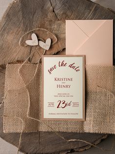 the wedding stationery is laid out on a piece of wood