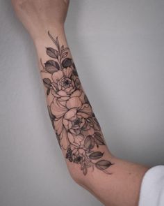 a woman's arm with black and white flowers on it