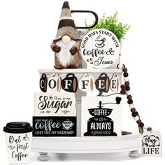 an assortment of coffee signs and decorations on a white stand with a green plant in the background