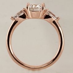 White Sapphire Engagement Ring/ Rose Gold Engagement Ring / Pear White sapphires / Round Moissanite Ring EF color/ 14K Gold Diamond Ring Video of this ring with 6.5 mm Moissanite in the center: https://m.youtube.com/watch?v=OA6NudE_I-A Product specifications: You can also choose any of these options: -White Gold 14K -Yellow Gold 14K -Rose Gold 14K Center stone: You can choose any of these options: -Simulated Diamond - Cubic Zirconia 6.5 mm OR -Certified Round Moissanite 5 mm diamond equivalent w Rose Gold Diamond Ring With Rose Cut Baguette, Rose Gold Baguette Cut Ring With Rose Cut Diamonds, Morganite Three Stone Jewelry For Wedding, Morganite Brilliant Cut Diamond Ring, Rose Gold Baguette Cut Ring With Center Stone, Rose Gold Sapphire Ring With Rose Cut Diamonds, Rose Gold Moissanite Ring Baguette Cut, Trillion Cut Ethical Diamond Ring In Rose Gold, Morganite Three-stone Wedding Rings