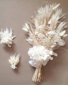 some white flowers and feathers on a gray surface with one flower in it's center