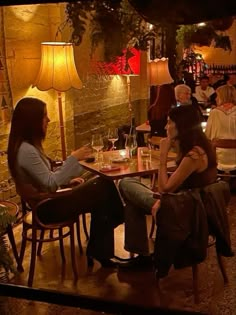 two women sitting at a table talking to each other