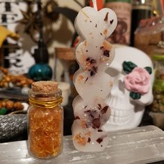 a jar filled with lots of candy next to a skull statue and some other items