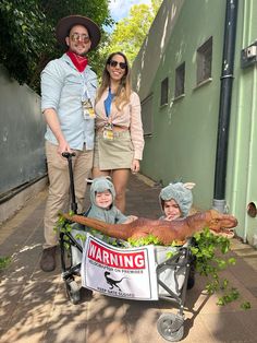 two adults and one child are in a wagon that is decorated with fake alligators