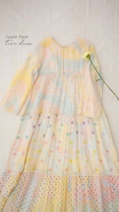 Feel spirited in our Ripple Float Dress tie dyed in pastel yellow with accents of fuchsia and arctic blue and hand block printed with flora and polka dot prints. Constructed in three tiers with soft gathers, this dress is an everyday autumn staple. Indian Gowns Dresses, Indian Gowns, Girls Fashion Clothes