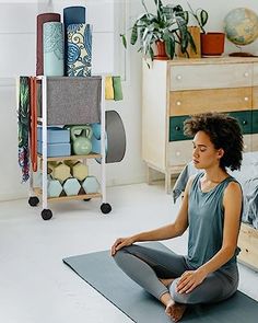 a woman sitting on a yoga mat in her bedroom