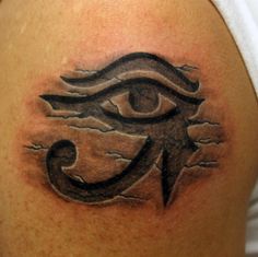 an eye tattoo on the back of a man's shoulder