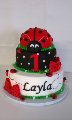 a three tiered cake decorated with ladybug decorations