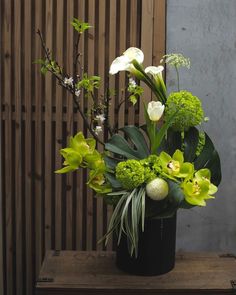 a vase filled with green and white flowers