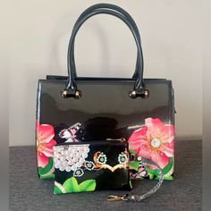 This Gorgeous Black Floral Bag Is Brand New! Large Floral Detailing In Bright And Beautiful Shades On The Bag As Well As The Small Coin Bag Are Eye Catching. This Purse Is Not For Those That Don’t Want To Be Noticed. It’s A Purse For Those That Like Being Seen Because Of Their Immaculate Taste In Purses. This Purse Can Also Be Used As A Crossbody. This Beauty Comes With: Details: * Zippered Center Compartment * Zippered Inside Side Pocket * 2 Inside Side Pockets * Zippered Small Credit Card/Coin Elegant Floral Print Top Handle Shoulder Bag, Elegant Top Handle Bag With Floral Print, Black Floral Print Tote Bag, Floral Print Formal Bags For Spring, Formal Floral Print Bags For Spring, Formal Floral Print Bag For Spring, Formal Spring Floral Print Bags, Black Rectangular Shoulder Bag With Floral Print, Rectangular Floral Print Shoulder Bag For Evening