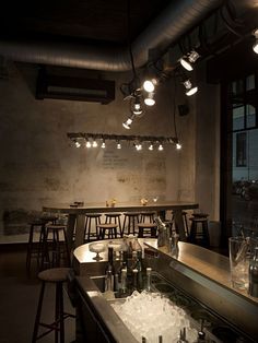 a dimly lit bar with lots of bottles and glasses on the counter in front of it