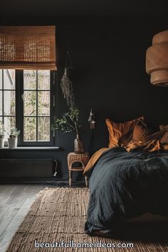 a bedroom with black walls and wooden flooring