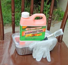 a plastic container sitting on top of a wooden chair next to a bottle of soap