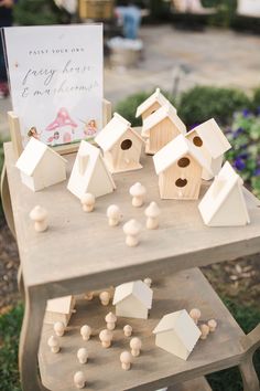 wooden birdhouses are arranged on a small table