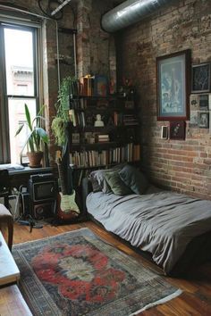 a bed sitting in the middle of a living room next to a book shelf filled with books