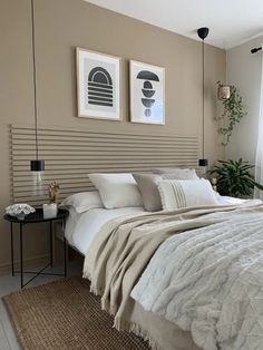 a bed with two pictures on the wall above it