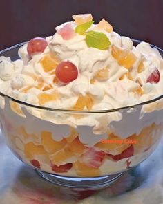 a glass bowl filled with fruit salad on top of a table