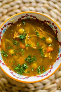 a bowl filled with soup sitting on top of a woven table cloth next to a basket