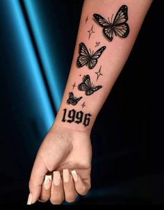 a woman's arm with butterflies on it and the number 1994 written in black ink