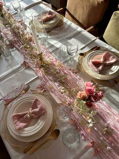 the table is set with pink napkins and place settings