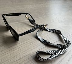 Uniquely handcrafted braided sunglasses chain designed with aesthetics and functionally in mind. Key features: - Lightweight and comfortable - Securely attaches to your glasses using silicone eyelets - Two tone braided design Length: 75cm     Width: 1.5cm Trendy Adjustable Sunglasses For Travel, Modern Adjustable Sunglasses For Beach, Black Glasses Chains For Summer Beach, Trendy Adjustable Glasses Chains For Everyday Use, Trendy Adjustable Glasses Chains, Trendy Black Glasses Chains As Fashion Accessory, Trendy Black Glasses Chains For Everyday, Trendy Adjustable Glasses Chains As Fashion Accessory, Trendy Adjustable Glasses Chains For Vacation